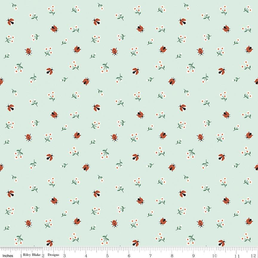 a repeating pattern of small green leaves and orange ladybugs on a light blue background.