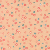 a repeating pattern of small flowers in various shades of pink and blue against a peach background.