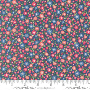 The image is a close-up of a fabric with a floral pattern, featuring small red, pink, and blue flowers scattered across a dark blue background.