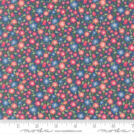 The image is a close-up of a fabric with a floral pattern, featuring small red, pink, and blue flowers scattered across a dark blue background.