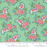 The image is a fabric with a paisley pattern in shades of green, pink, and blue. The pattern consists of various paisley designs and floral elements, creating a vibrant and visually appealing design.
