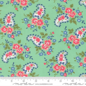 The image is a fabric with a paisley pattern in shades of green, pink, and blue. The pattern consists of various paisley designs and floral elements, creating a vibrant and visually appealing design.