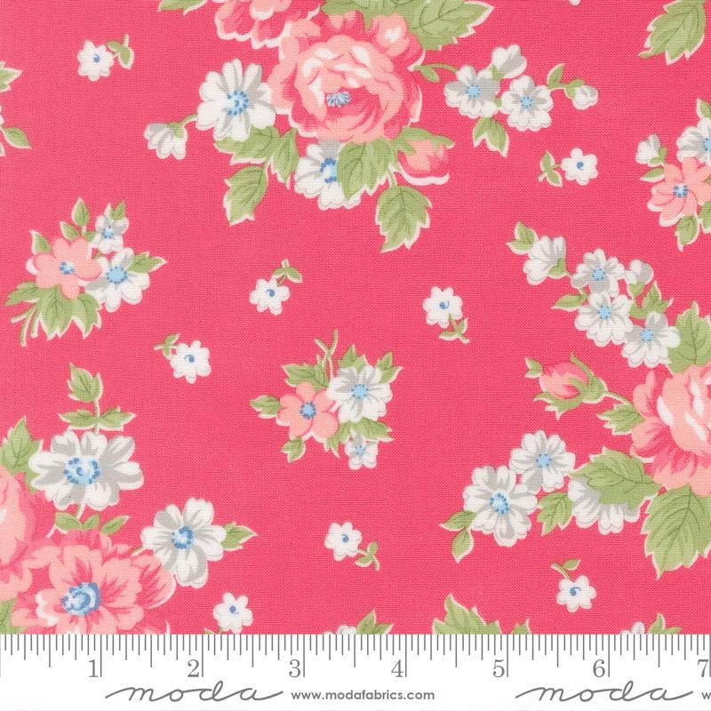 a vibrant pink fabric adorned with a floral pattern of white and pink flowers, along with green leaves. The fabric appears to be a part of a larger textile or garment, as indicated by the ruler for scale.