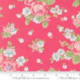 a vibrant pink fabric adorned with a floral pattern of white and pink flowers, along with green leaves. The fabric appears to be a part of a larger textile or garment, as indicated by the ruler for scale.