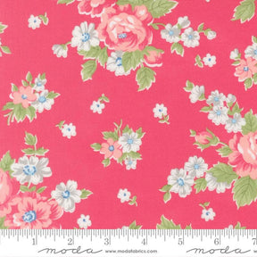 a vibrant pink fabric adorned with a floral pattern of white and pink flowers, along with green leaves. The fabric appears to be a part of a larger textile or garment, as indicated by the ruler for scale.