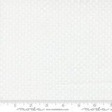The image is a white fabric with a repeating pattern of small white flowers or leaves. The fabric appears to be a type of lace or sheer material, as it has a delicate and intricate design. The fabric is displayed on a ruler for scale, indicating its size.