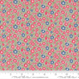 The image is a fabric with a floral pattern in shades of pink, blue, and green. The pattern consists of small flowers and leaves scattered across the fabric, creating a visually appealing and colorful design.