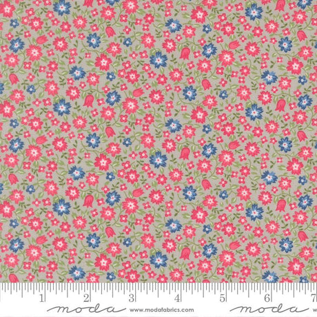 The image is a fabric with a floral pattern in shades of pink, blue, and green. The pattern consists of small flowers and leaves scattered across the fabric, creating a visually appealing and colorful design.