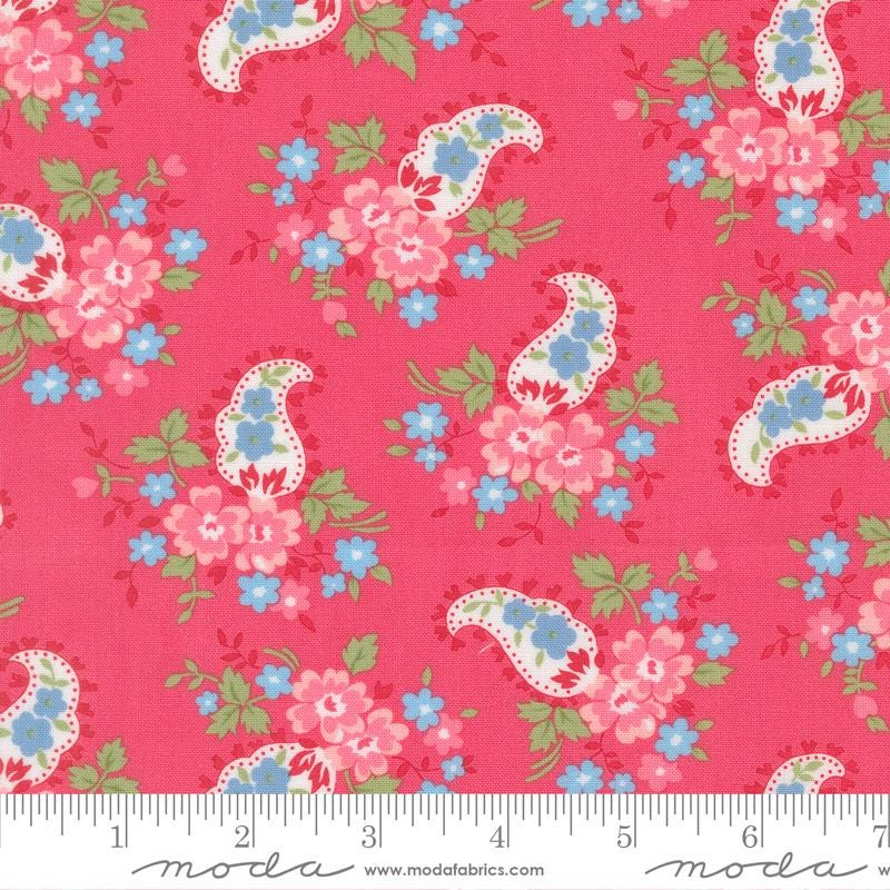 The image is a vibrant red fabric with a repeating paisley pattern of pink and blue flowers and leaves.