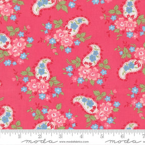 The image is a vibrant red fabric with a repeating paisley pattern of pink and blue flowers and leaves.