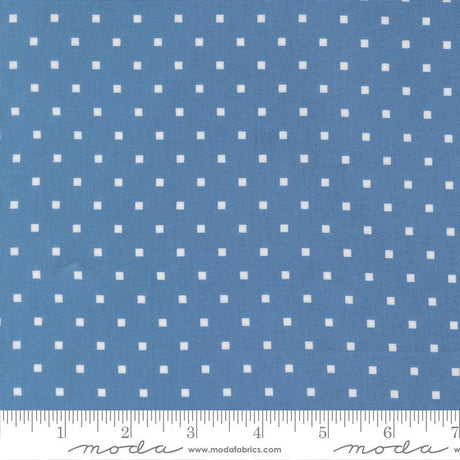 a close-up view of a fabric with a blue background and white polka dots. The fabric appears to be a type of textile, possibly used for clothing or home decor.
