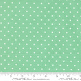 a fabric with a green background and white polka dots.