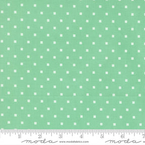 a fabric with a green background and white polka dots.