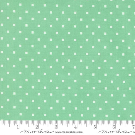 a fabric with a green background and white polka dots.