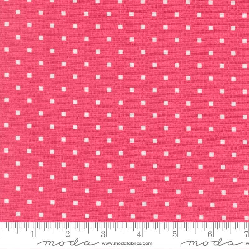 a close-up view of a fabric with a repeating pattern of small white squares against a bright pink background.