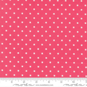 a close-up view of a fabric with a repeating pattern of small white squares against a bright pink background.