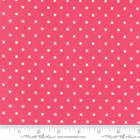 a close-up view of a fabric with a repeating pattern of small white squares against a bright pink background.