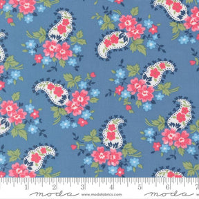 a blue fabric with a paisley pattern of pink and white flowers and leaves.