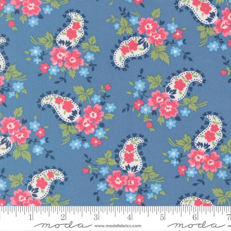 a blue fabric with a paisley pattern of pink and white flowers and leaves.
