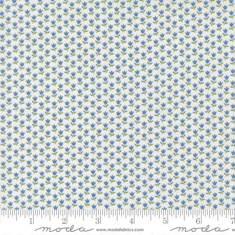 a fabric with a repeating pattern of blue flowers on a white background. The pattern is arranged in a grid-like fashion, creating a visually appealing and intricate design.