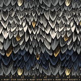 The image is a close-up of a textured surface with a repeating pattern of gray, black, and white feathers.