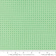 The image is a fabric with a green pattern, featuring small square shapes arranged in a grid-like pattern.