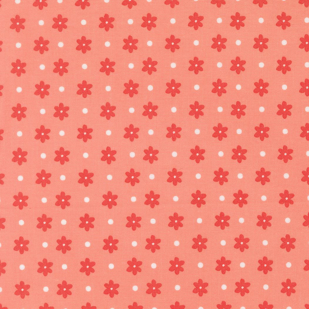 a repeating pattern of red flowers with white polka dots on a peach-colored background.