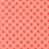 a repeating pattern of red flowers with white polka dots on a peach-colored background.