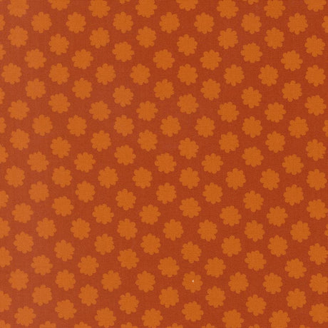 a repeating pattern of orange and brown flowers or shapes on a brown background.