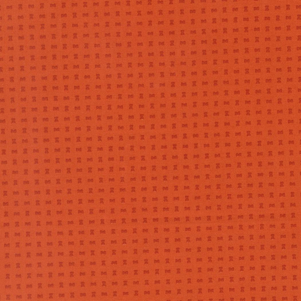 The image is a close-up of a textured orange surface with small square patterns.