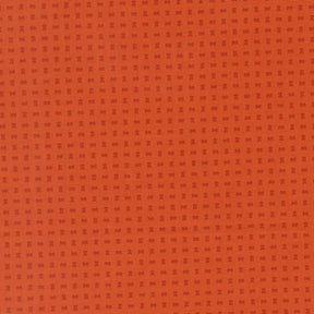 The image is a close-up of a textured orange surface with small square patterns.