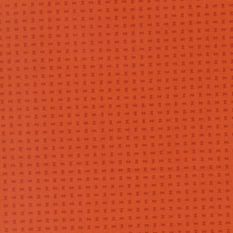 The image is a close-up of a textured orange surface with small square patterns.
