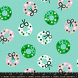 a pattern of Christmas wreaths with green bows and pink and white polka dots on a light blue background.
