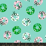 a pattern of Christmas wreaths with green bows and pink and white polka dots on a light blue background.