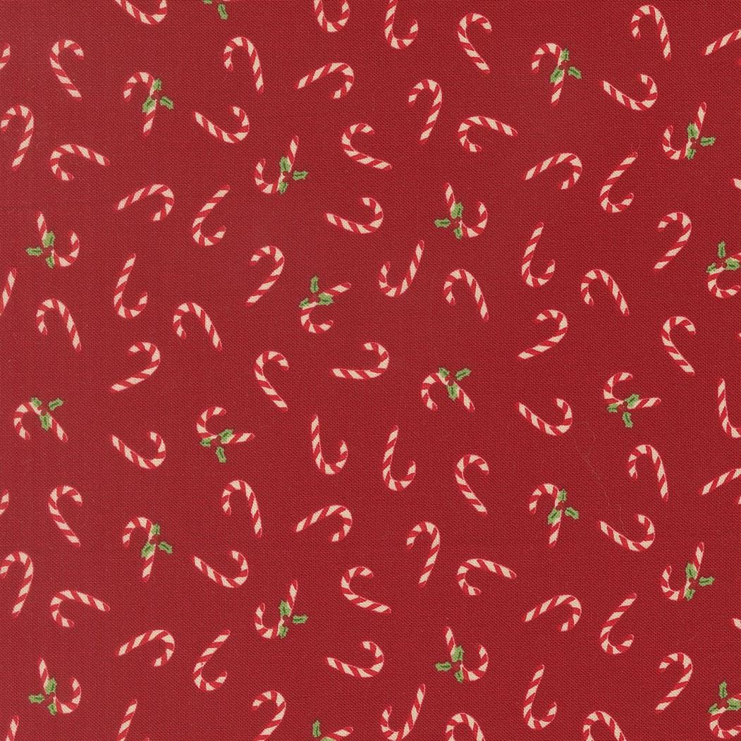a pattern of red fabric with white and green candy canes scattered across it.
