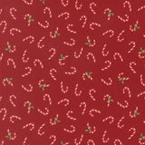 a pattern of red fabric with white and green candy canes scattered across it.