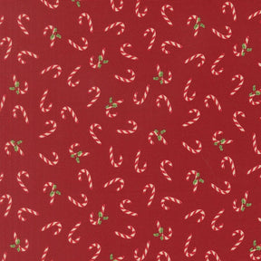 a pattern of red fabric with white and green candy canes scattered across it.