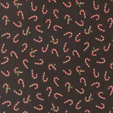 numerous red and white striped candy canes scattered across a dark background.