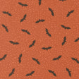 a repeating pattern of black bats against a textured orange background with small white dots, creating a visually striking and festive design.