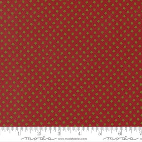 a red fabric with a repeating pattern of gold stars on it. The fabric appears to be a fabric with a star pattern, possibly used for clothing or home decor.