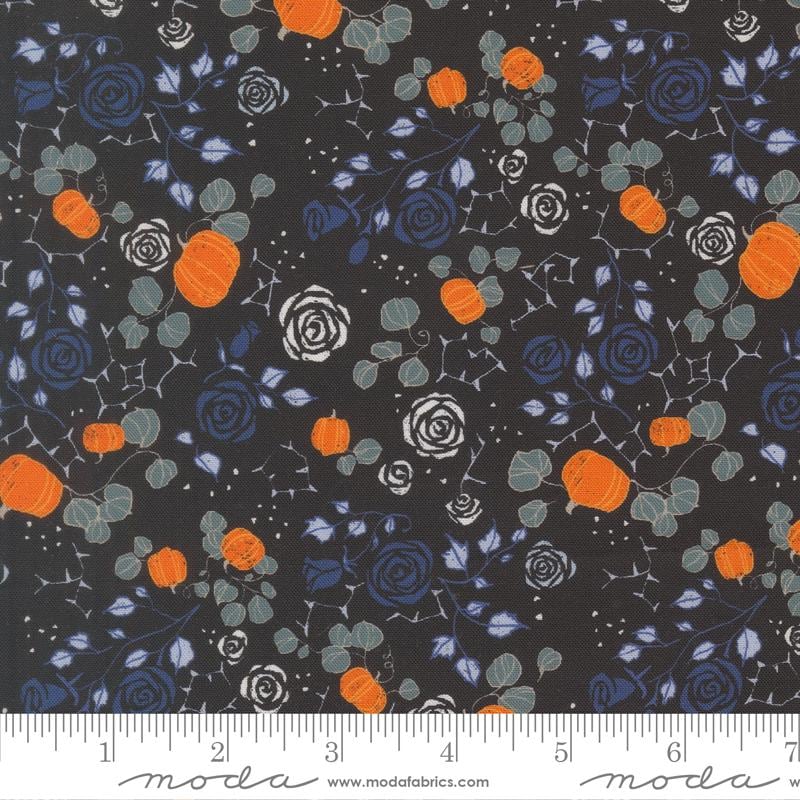 The image is a fabric with a floral pattern featuring orange pumpkins, blue roses, and gray leaves against a dark background.
