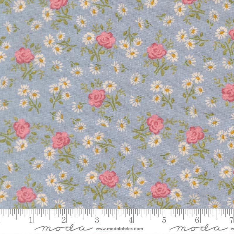 The image is a fabric with a floral pattern of pink roses and white daisies on a light blue background.