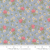 The image is a fabric with a floral pattern of pink roses and white daisies on a light blue background.