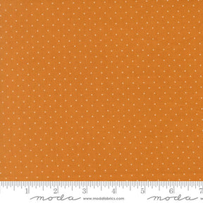 The image is a close-up of a fabric with a polka dot pattern, featuring a gradient of orange and white colors.