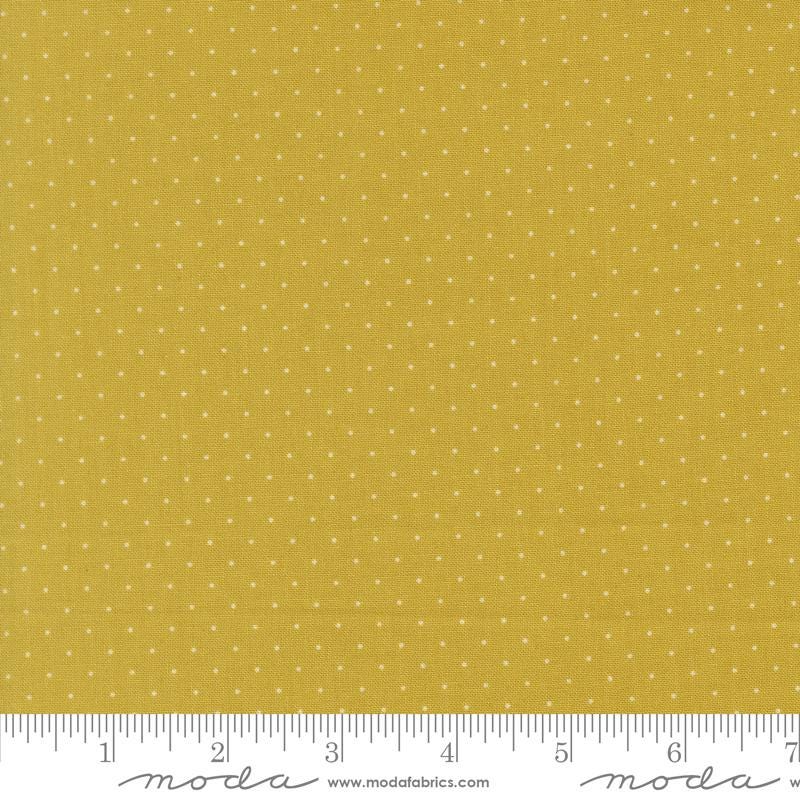 The image is a close-up of a fabric with a yellow background and white polka dots.