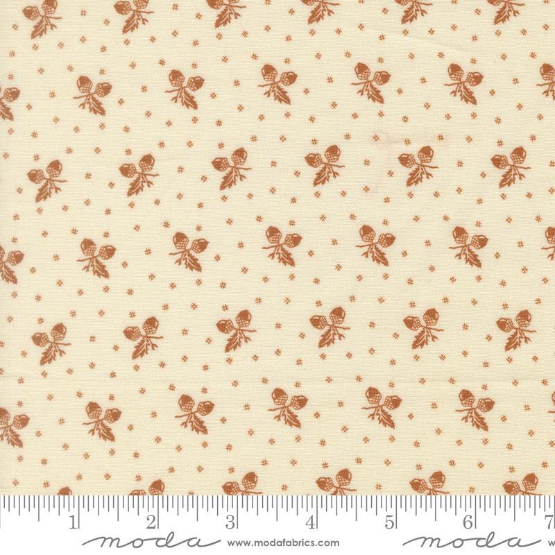 a repeating pattern of brown acorns on a cream-colored background.