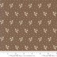 a brown fabric with a repeating pattern of white acorns and leaves. The pattern is composed of small white dots, creating a visually appealing and intricate design. The fabric appears to be a piece of clothing or textile, with the acorn and leaf motifs possibly used for embellishment or decoration.