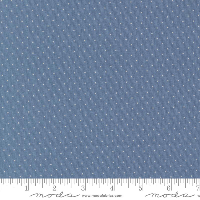 a close-up view of a fabric with a blue background and white polka dots. The fabric appears to be a type of textile, possibly used for clothing or home decor.