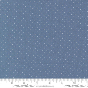 a close-up view of a fabric with a blue background and white polka dots. The fabric appears to be a type of textile, possibly used for clothing or home decor.