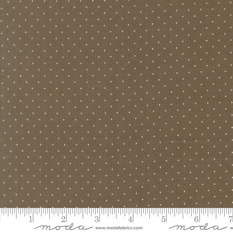 The image is a close-up of a fabric with a brown background and white polka dots.